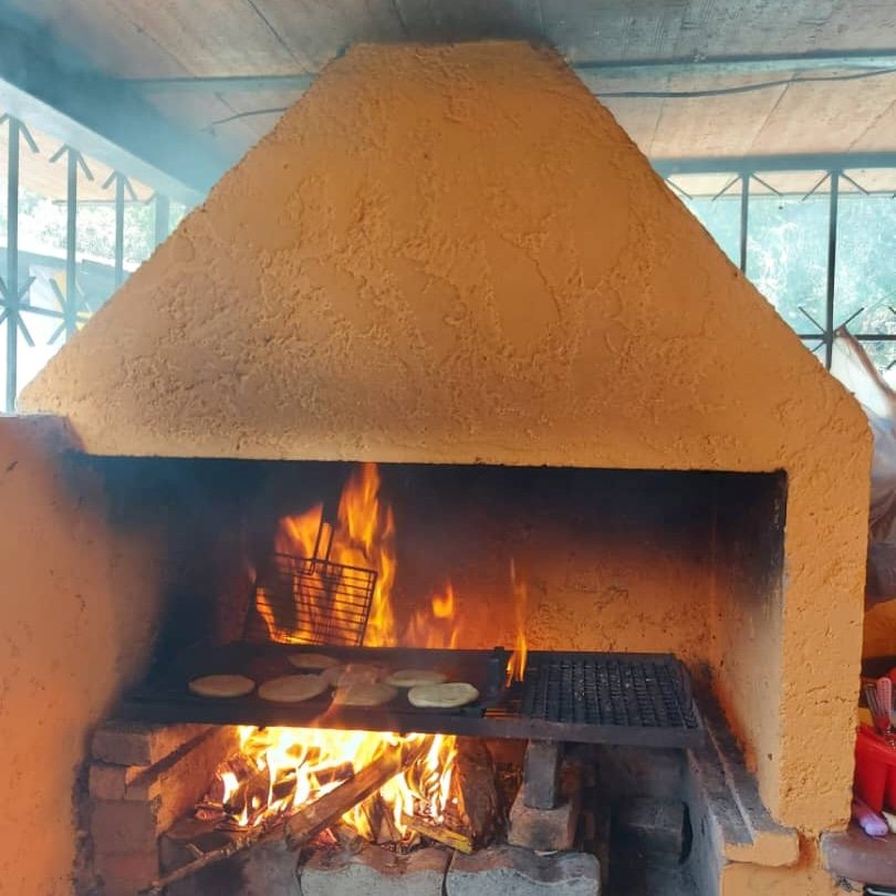 Parrillera encendida y cocina rustica de la posada
